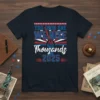 "You Took One We Rise As Thousands 2025" text with patriotic stars and stripes design on a navy t-shirt