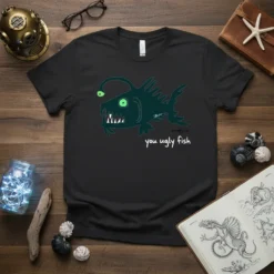 Black t-shirt featuring a cartoon anglerfish with a lure and sharp teeth, text reads "you ugly fish"