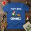 Blue t-shirt with white text "You've been GNOMED" and a cartoon gnome pulling a cart of traffic cones