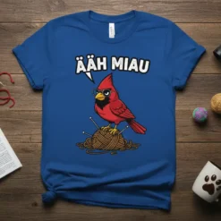 Funny ÄAH MIAU cardinal wearing glasses, perched on yarn with knitting needles, text above