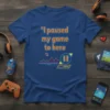 T-shirt with quote "I paused my game to here" and retro video game graphic with pause button