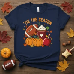 'Tis The Season text with football, pumpkin, and hot cocoa graphics on a navy t-shirt