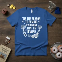 Blue t-shirt with white text "'Tis The Season To Remind Everyone That I'm Jewish" and Hanukkah graphics like menorahs and