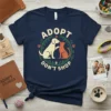ADOPT DON'T SHOP text with illustration of a dog and cat embracing, surrounded by leaves and paw prints