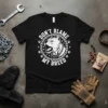 Black t-shirt with white text "DON'T BLAME MY BREED" and a graphic of a Pitbull's head surrounded by chains and