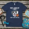 T-shirt with "Don't Judge My Pitbull And I Won't Judge Your Kids" text and a smiling pitbull graphic