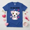 Blue t-shirt with "I'm So Cute" text and a white puppy face covered in pink kiss marks, surrounded by hearts
