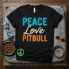 Peace Love Pitbull text design on a black t-shirt, with graphic elements like a peace sign and dog tag