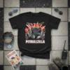 Black t-shirt with bold "PITBULLZILLA" text above a fierce pitbull head graphic surrounded by city buildings and helicopters
