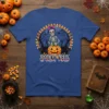 Spooky Vibes Halloween t-shirt design with a skeleton on a pumpkin, two black cats, and candy corn border
